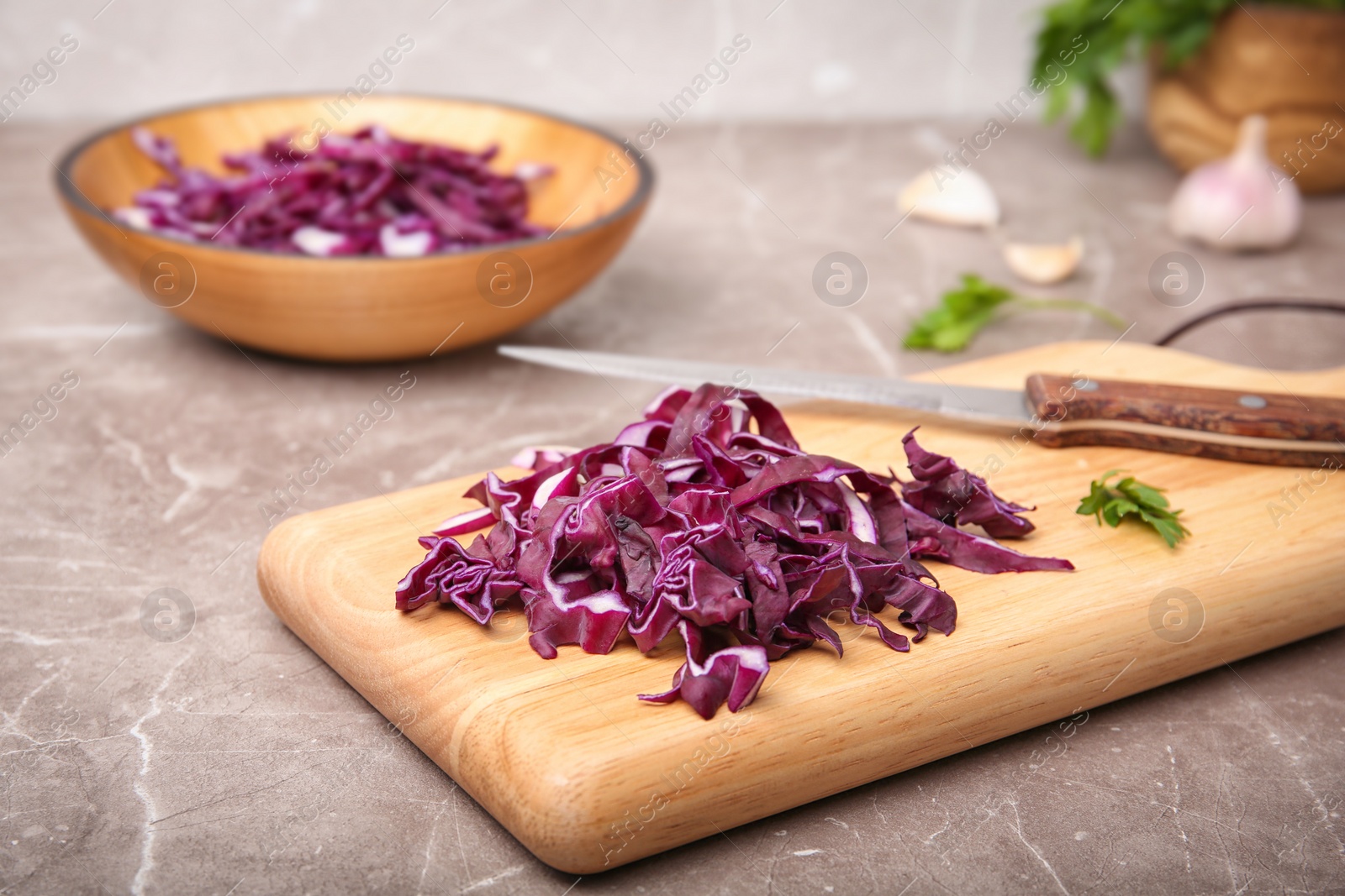 Photo of Wooden board with chopped red cabbage on table