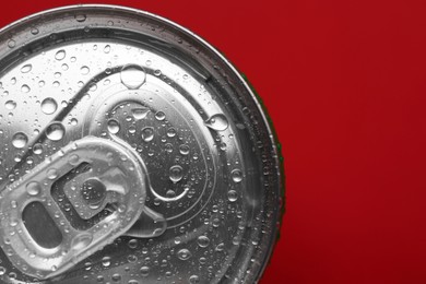 Photo of Energy drink in wet can on red background, top view. Space for text