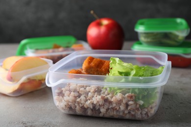 Photo of Set of plastic containers with fresh food on light grey table