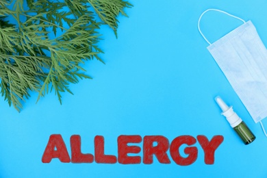 Ragweed (Ambrosia), word ALLERGY and medication on blue background, flat lay. Space for text