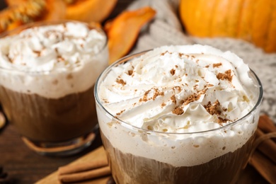 Photo of Glass with tasty pumpkin spice latte on table, closeup