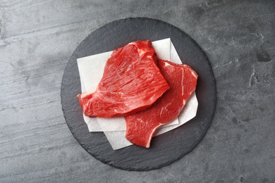 Photo of Fresh raw beef cut on grey table, top view