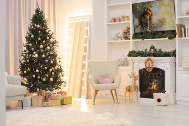 Photo of Beautiful Christmas tree and fireplace in living room