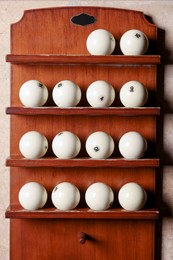 Photo of Set of billiard balls on wooden shelves indoors