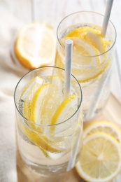 Photo of Soda water with lemon slices and fresh fruits on table, closeup