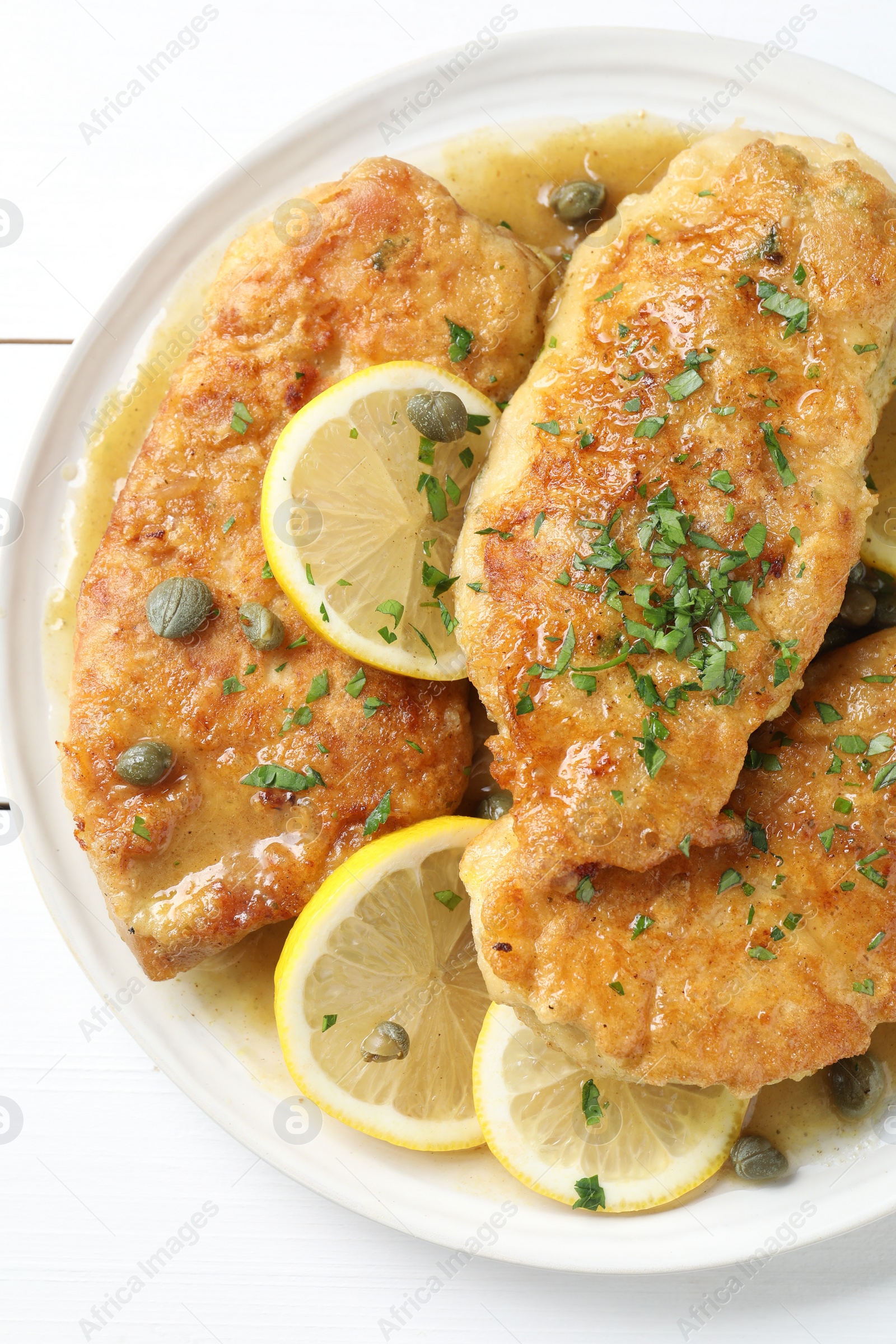 Photo of Delicious chicken piccata on white table, top view