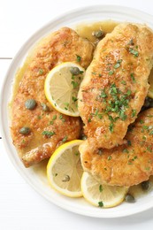 Delicious chicken piccata on white table, top view