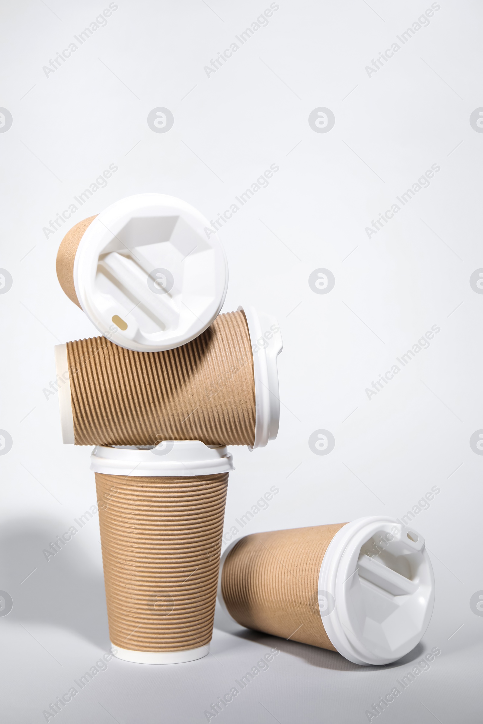 Photo of Paper cups with white lids on light gray background. Coffee to go