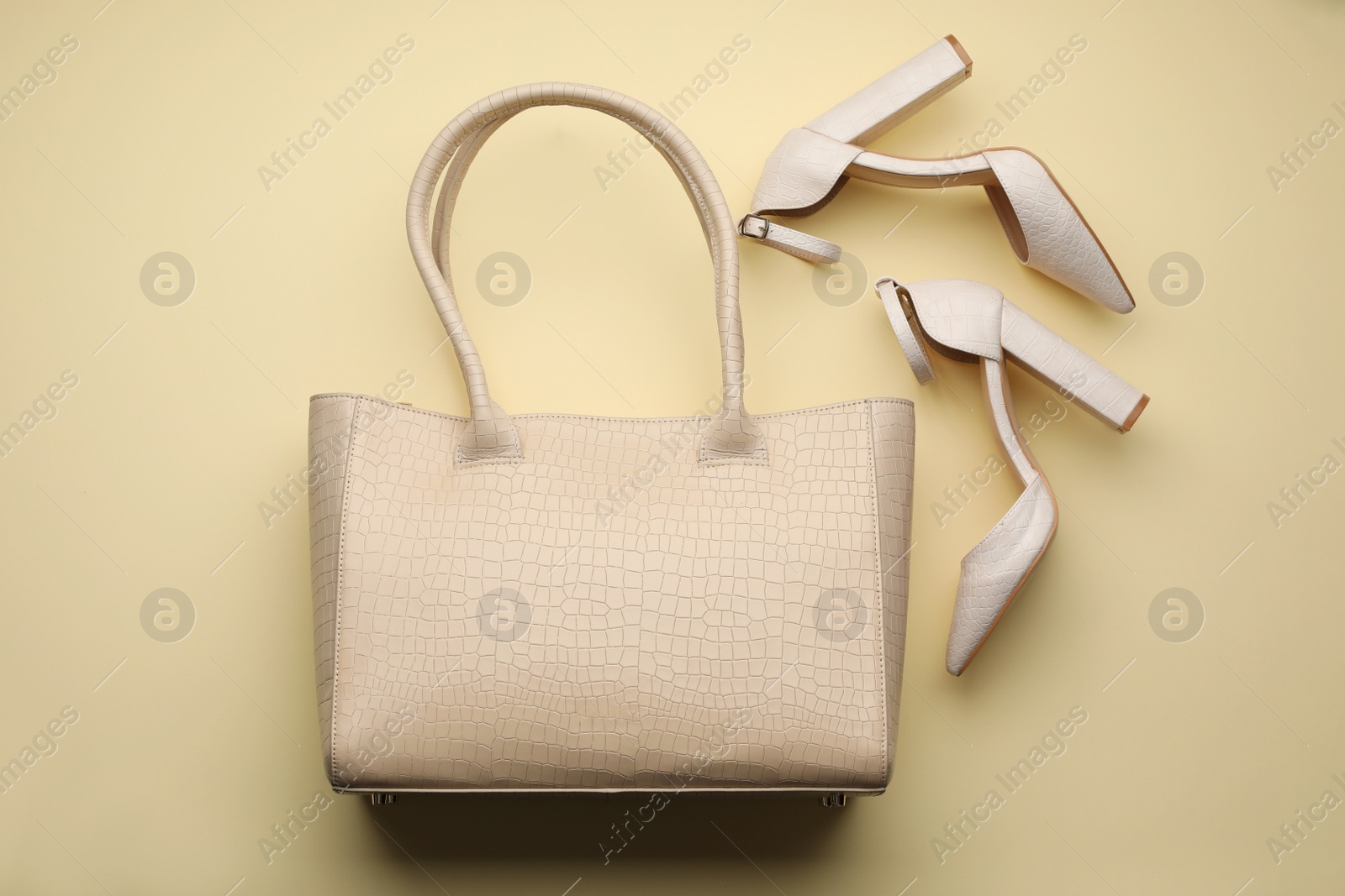 Photo of Stylish woman's bag and shoes on beige background, flat lay