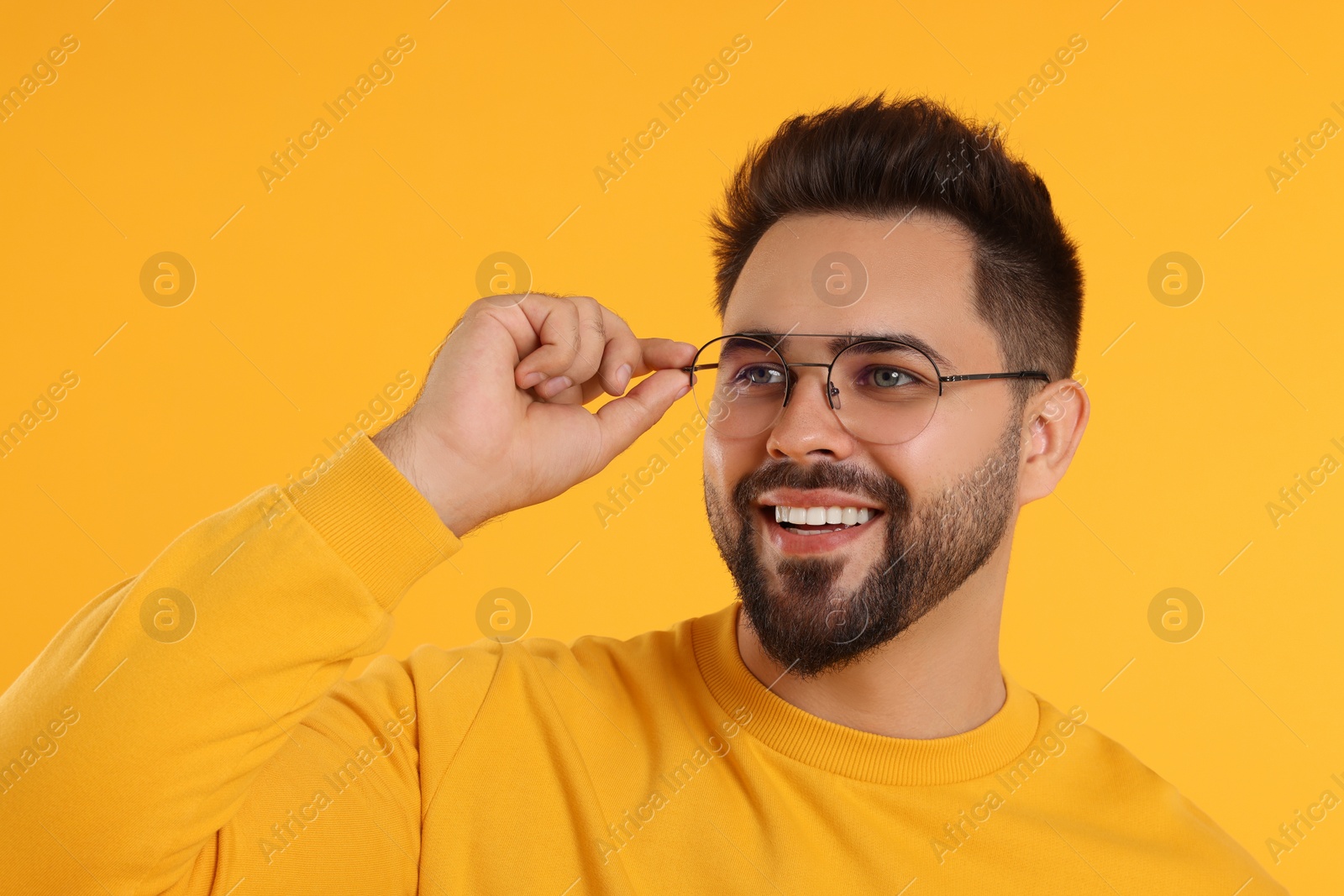 Photo of Handsome man wearing glasses on orange background