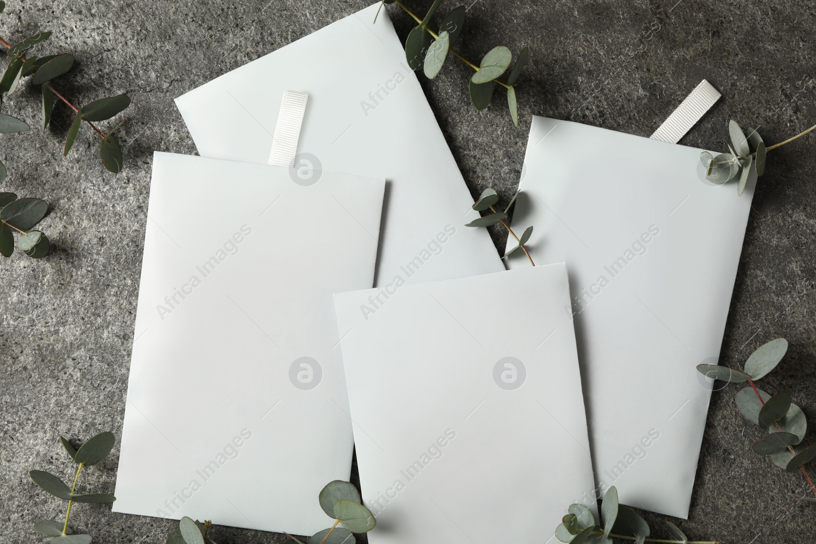 Photo of Scented sachets and eucalyptus branches on grey table, flat lay