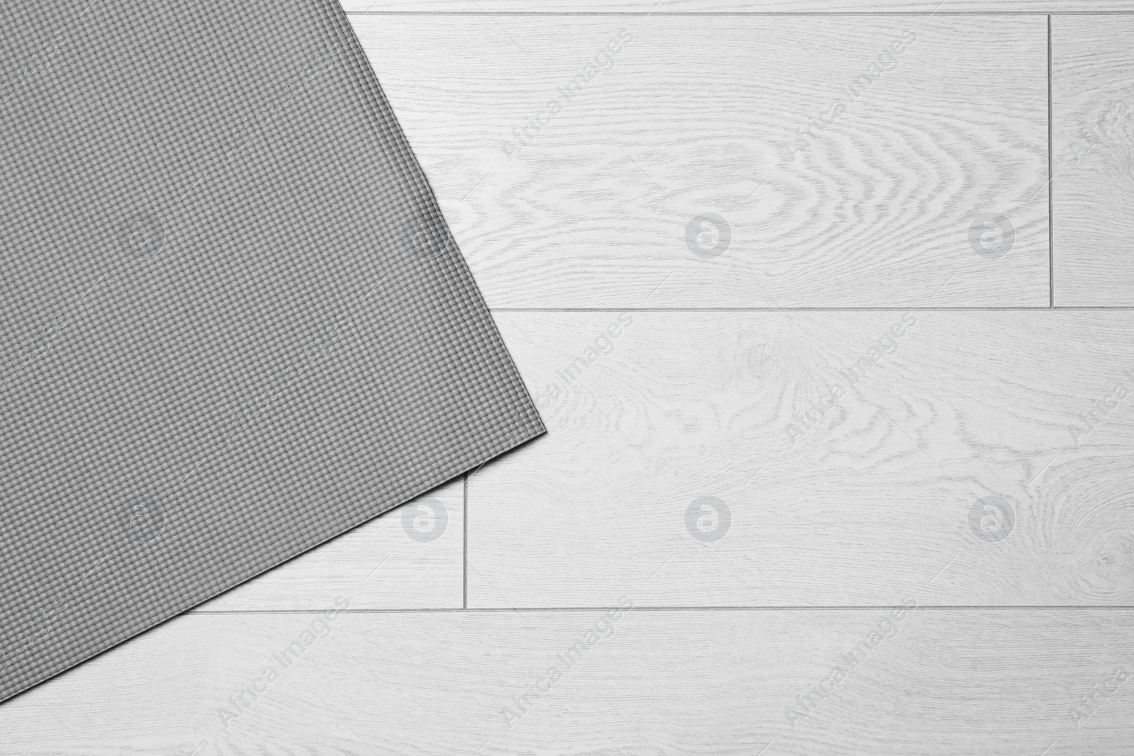 Photo of Grey sports mat on wooden background, top view with space for text