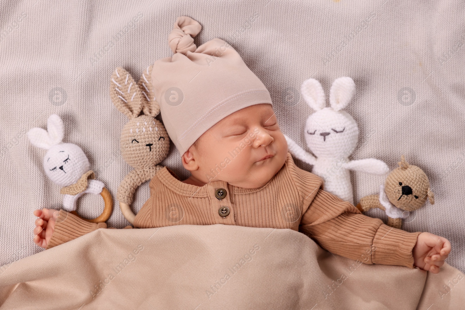 Photo of Cute newborn baby sleeping with toys in bed, top view