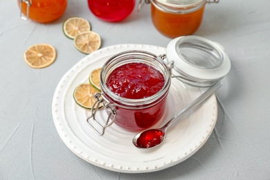 Photo of Jar and spoon with sweet jam on table