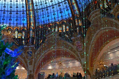 Paris, France - December 10, 2022: Crowded Galeries Lafayette Haussmann with beautiful Christmas decor
