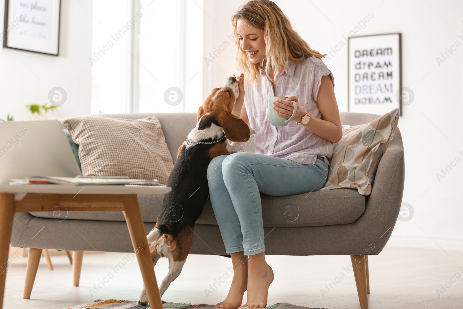 Photo of Young woman with her dog at home