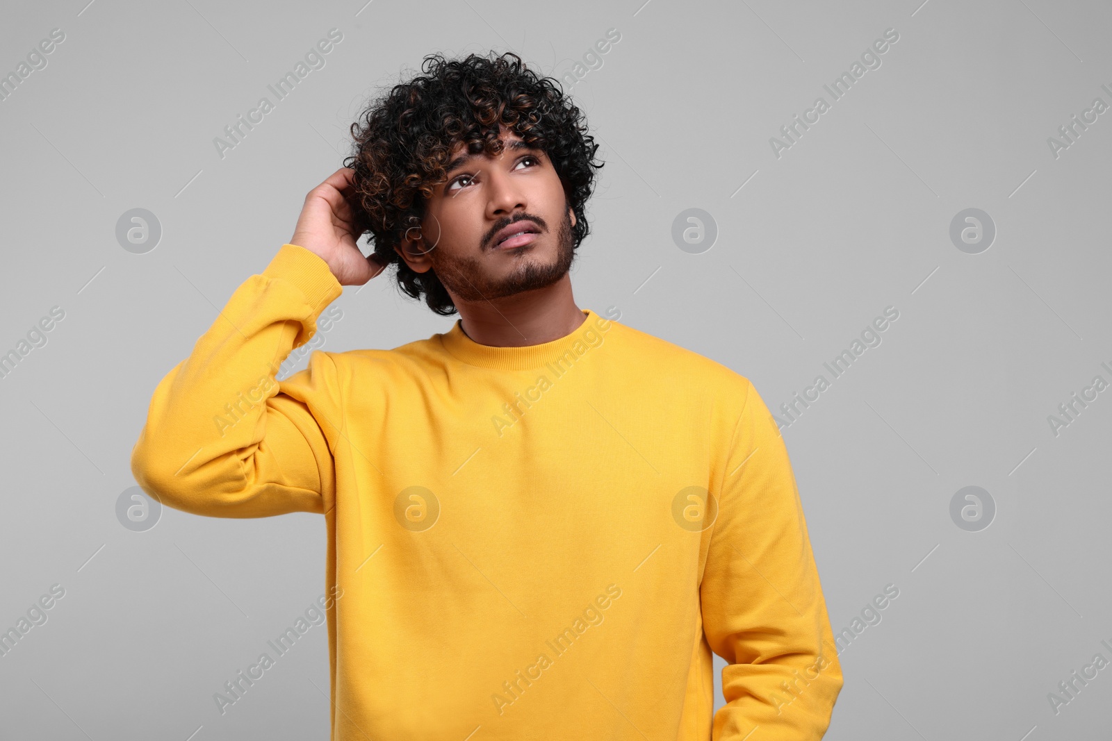 Photo of Handsome thoughtful man on light grey background. Space for text