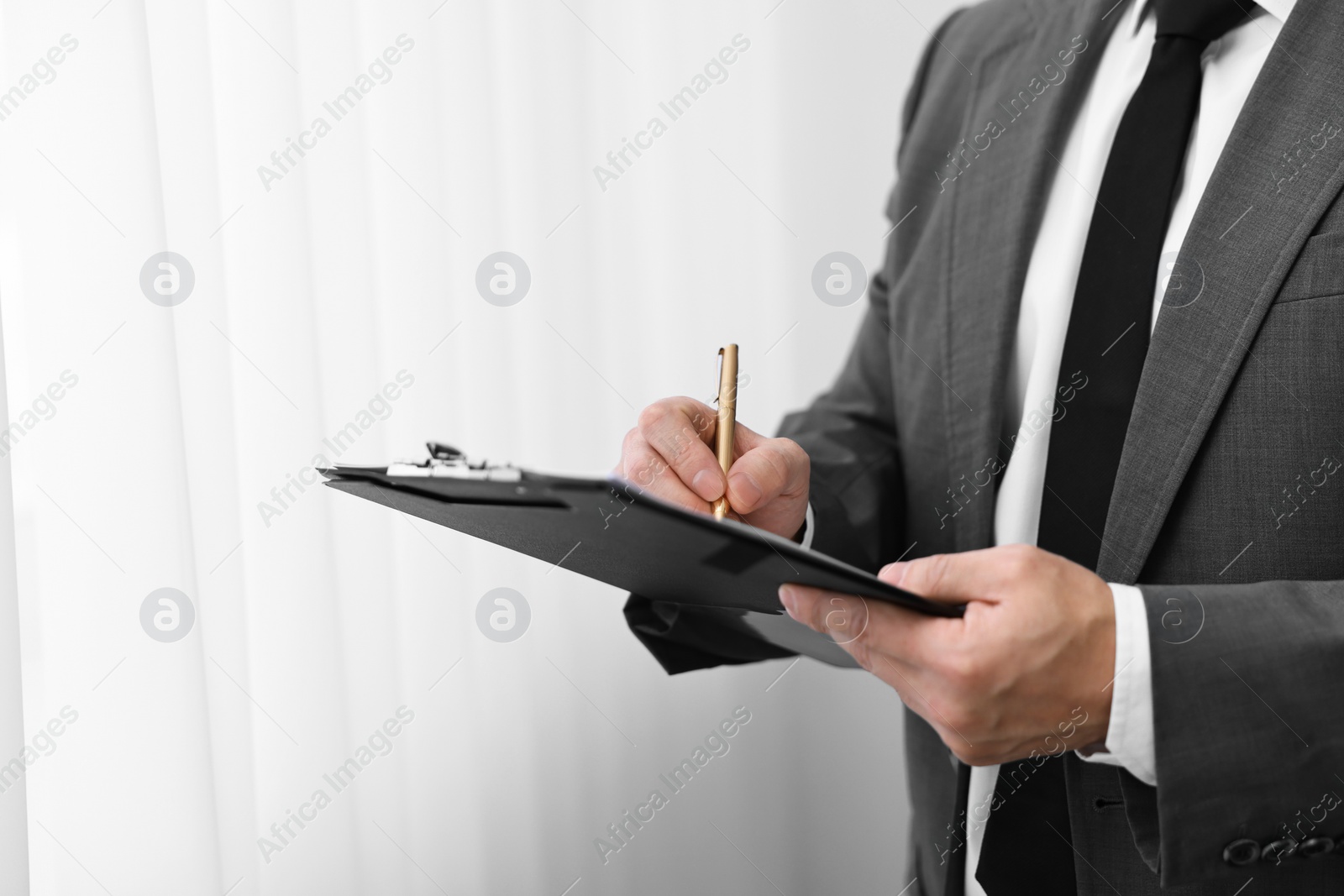 Photo of Notary writing notes in clipboard with pen indoors, closeup. Space for text