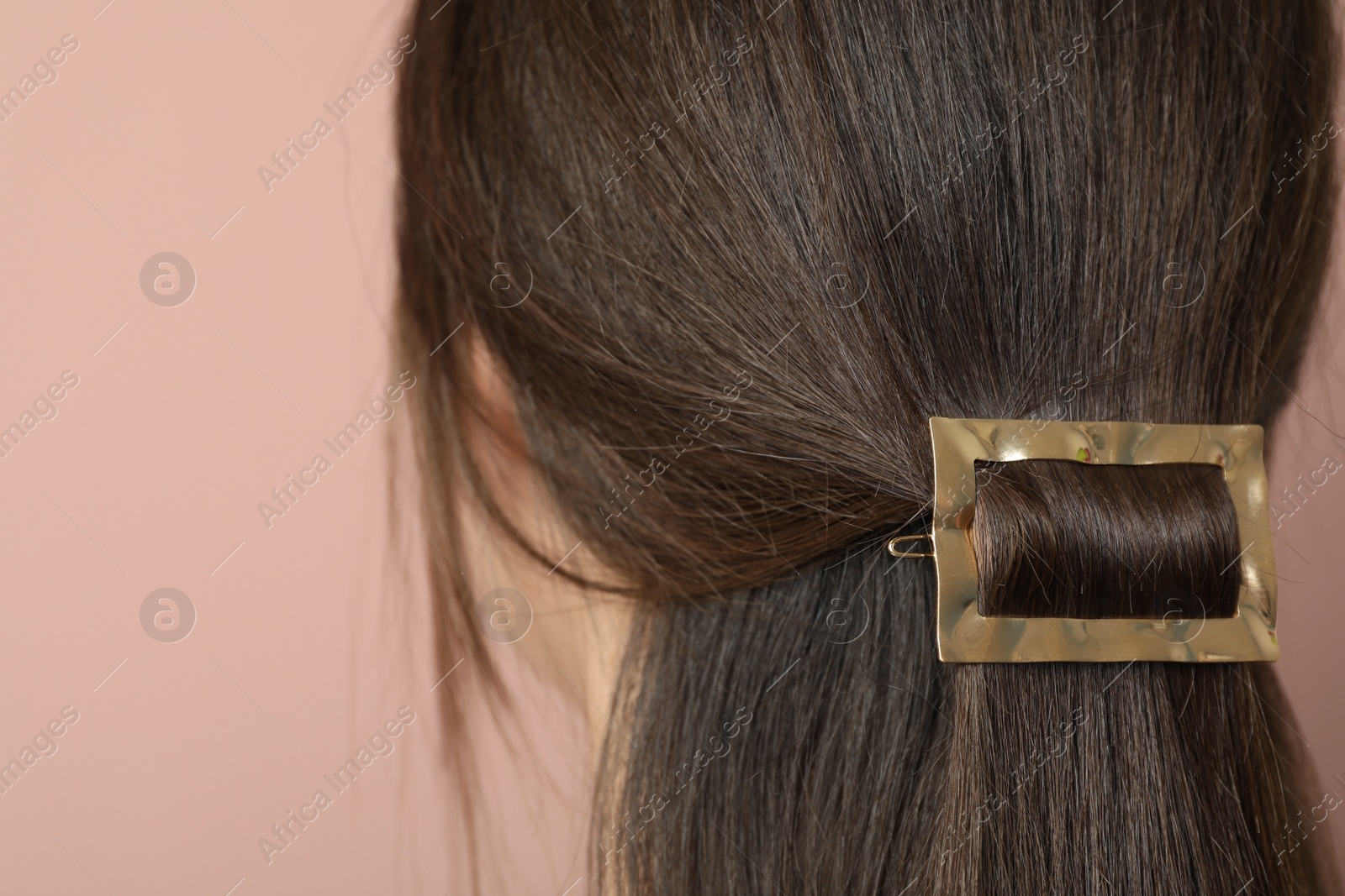 Photo of Young woman with beautiful gold hair clip on pink background, closeup