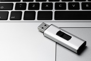 Modern usb flash drive on laptop, closeup. Space for text