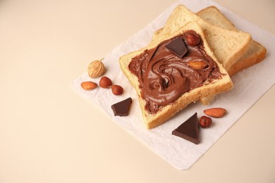 Photo of Tasty toast with chocolate paste and nuts on light background, space for text