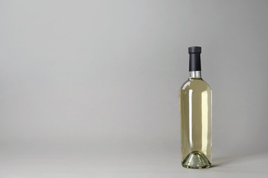 Photo of Bottle of wine on grey background. Space for text