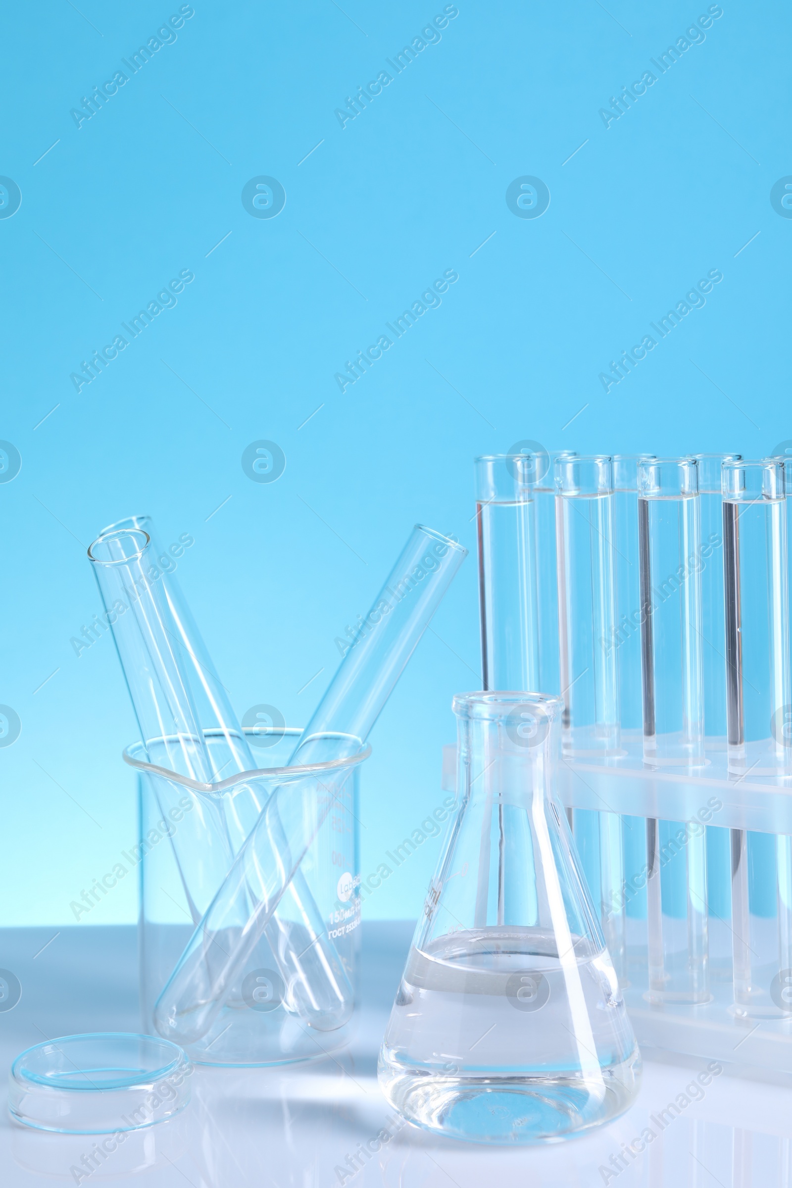 Photo of Laboratory analysis. Different glassware on table against light blue background