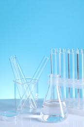 Photo of Laboratory analysis. Different glassware on table against light blue background