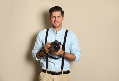 Photo of Professional photographer working on beige background in studio