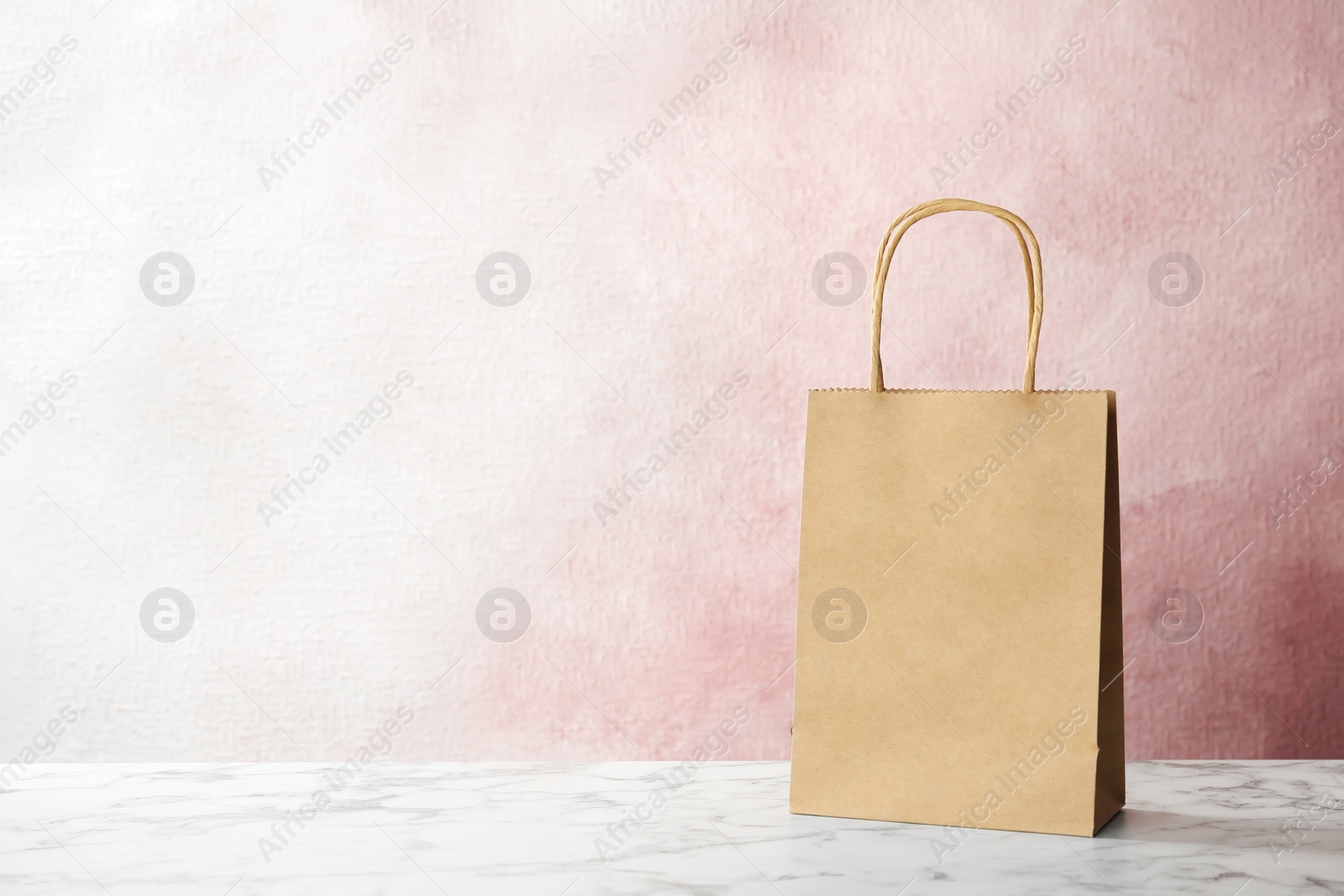 Photo of Mockup of paper shopping bag on table against color background