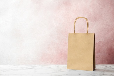 Photo of Mockup of paper shopping bag on table against color background