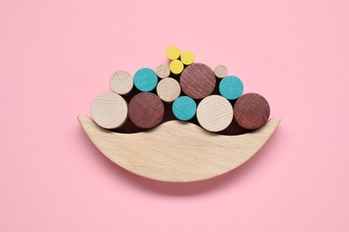 Photo of Wooden balance toy on pink background, flat lay. Children's development