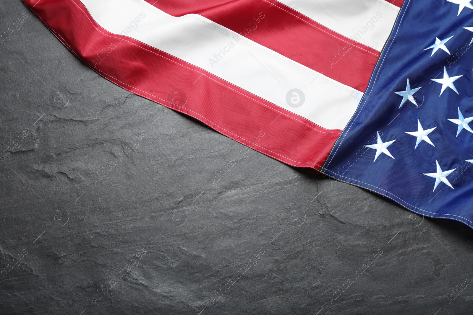 Photo of National flag of America on black table, top view. Space for text