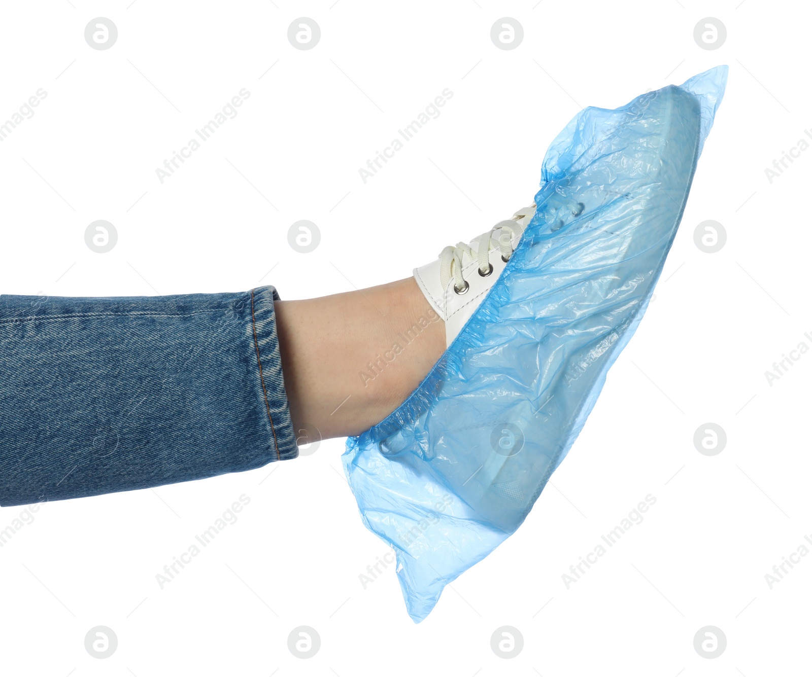 Photo of Woman wearing blue shoe cover onto her sneaker against white background, closeup