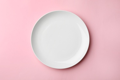 Clean empty plate on color background, top view