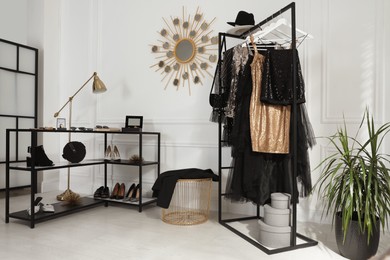 Photo of Stylish dressing room interior with trendy clothes, shoes and accessories