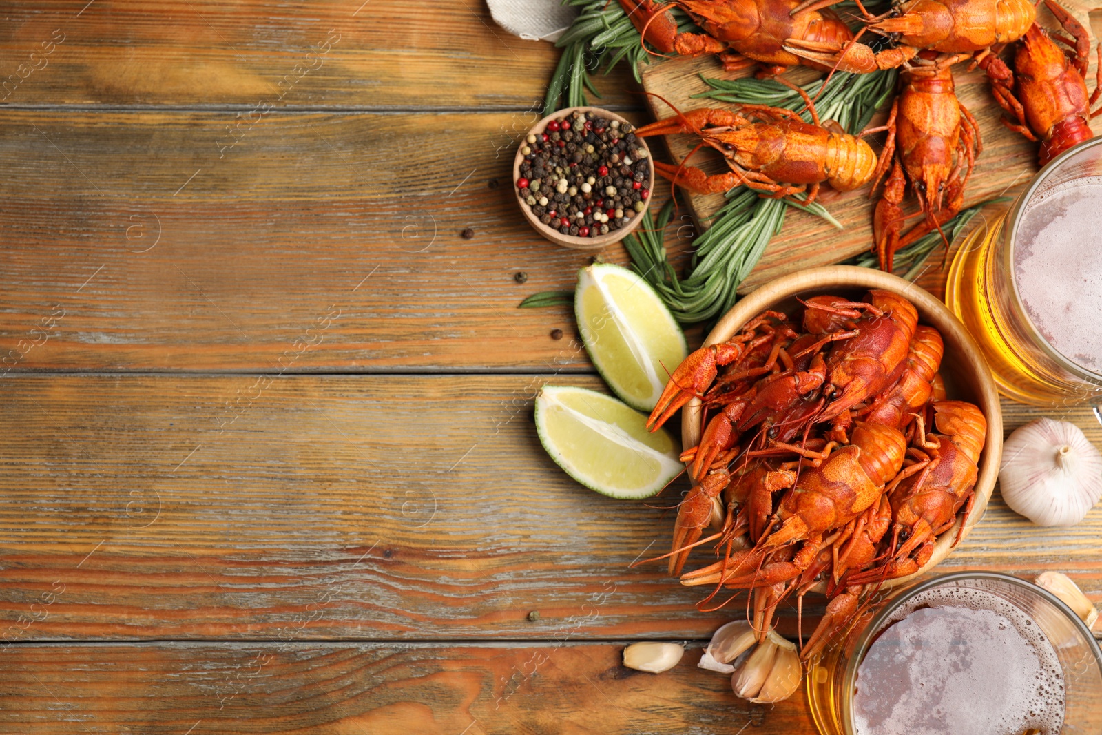 Photo of Flat lay composition with delicious red boiled crayfishes on wooden table, space for text