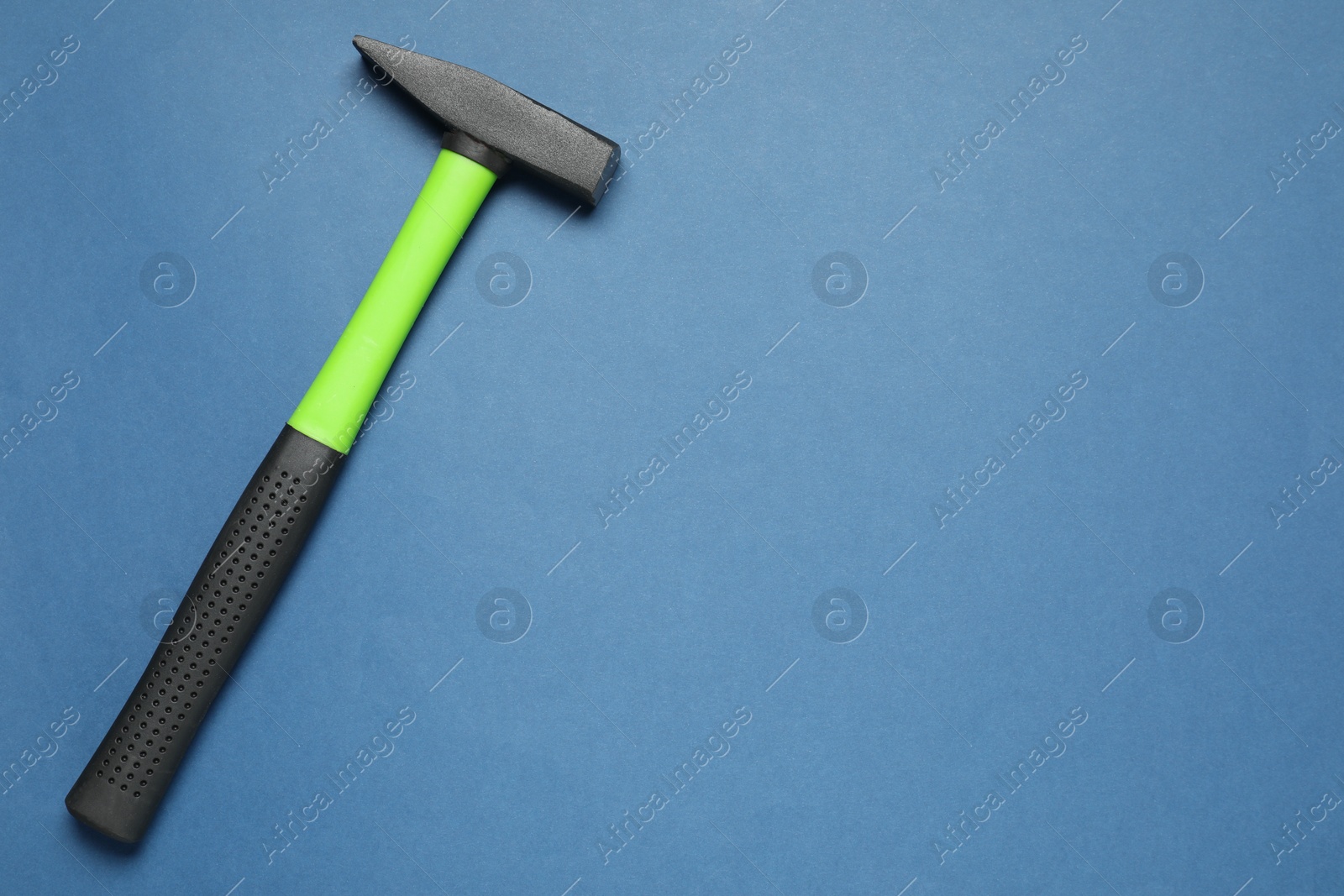 Photo of New hammer with rubber handle on blue background, top view. Space for text