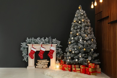 Photo of Stylish Christmas interior with decorated fir tree and fireplace