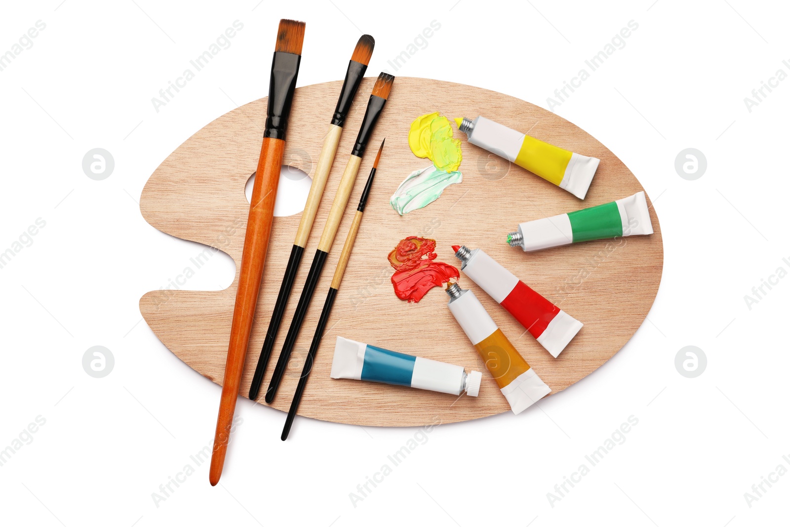 Photo of Wooden palette with oil paints and brushes on white background, top view