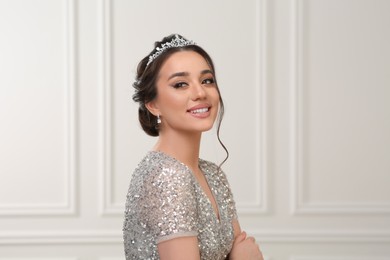 Photo of Beautiful young woman wearing luxurious tiara indoors