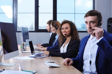 Photo of Team of technical support with headsets at workplace