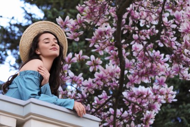 Photo of Beautiful woman near blossoming magnolia tree on spring day