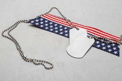 Photo of Military ID tags with USA flag on grey background