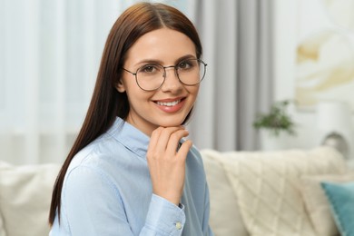 Photo of Portrait of smiling woman in stylish eyeglasses at home