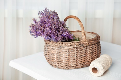 Photo of Wicker basket with lavender flowers on table indoors