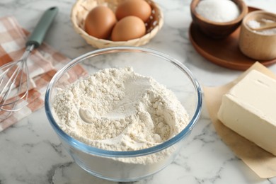 Photo of Making shortcrust pastry. Different ingredients for dough and whisk on white marble table