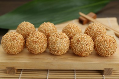 Photo of Many delicious sesame balls on wooden table, closeup
