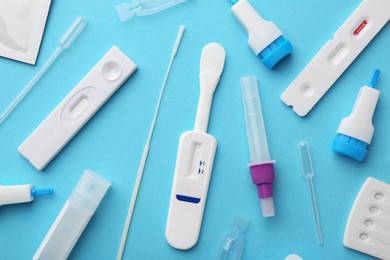 Photo of Disposable express test kits on light blue background, flat lay