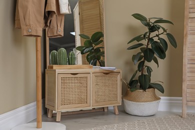 Photo of Stylish hallway room interior with wooden commode and large mirror
